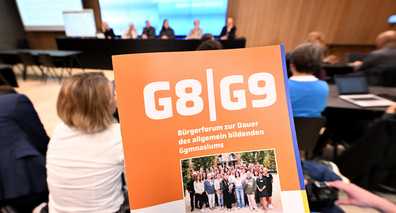 Eine Abbildung des Deckblatts der Kurzfassung des Bürgergutachtens zur Dauer des allgemein bildenden Gymnasiums während der Vorstellung in der Landespressekonferenz.