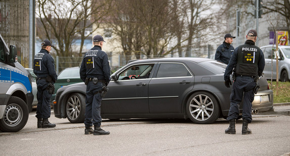 Polizisten kontrollieren vor Beginn eines Prozesses gegen mutmaßliche Führer der türkisch-nationalistischen Straßengang „Osmanen Germania BC“ auf dem Parkplatz vor dem Gerichtsgebäude ein Auto (Bild: © dpa).