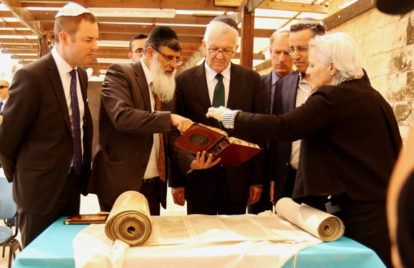 Ministerpräsident Winfried Kretschmann (M.) bei der Übergabe einer Tora