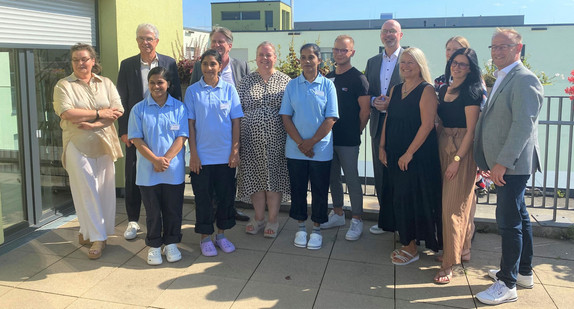 Minister Lucha und Christian Rauch, Vorsitzender der Geschäftsführung der Regionaldirektion Baden-Württemberg der Bundesagentur für Arbeit beim Gruppenfoto mit Mitarbeitenden und Verantwortlichen der Einrichtung @PASODI im Paritätische Mehrgenerationenzentrum in Stuttgart