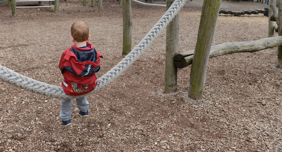 Ein fünfjähriger Junge sitzt allein auf einer Schaukel auf einem Abenteuerspielplatz. (Bild: © dpa)