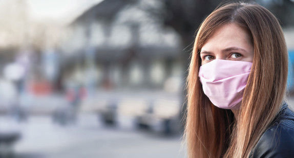 Eine junge Frau trägt einen selbstgemachten Mund- und Nasenschutz.