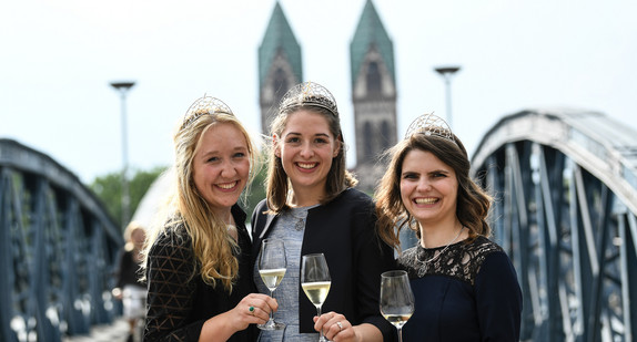 v.l.n.r.: Weinprinzessin Hannah Herrmann, Weinkönigin Miriam Kaltenbach und Weinprinzessin Stephanie Megerle stehen nach der Wahl und Krönung zur 69. Badischen Weinkönigin auf der Blauen Brücke. (Foto: © dpa)