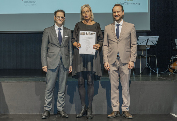 Verleihung des Staatspreises 2022 an Ute Kathrin Beck (v.l.n.r.): Ministerialdirektor Michael Kleiner, Ute Kathrin Beck, Erster Bürgermeister Christian Baron