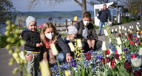 Eine Familie mit zwei Kindern schaut sich Blumen auf dem Gelände der Landesgartenschau in Überlingen an.