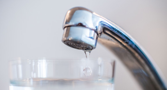 Wasser läuft aus einem Wasserhahn in ein Glas. (Foto: © dpa)