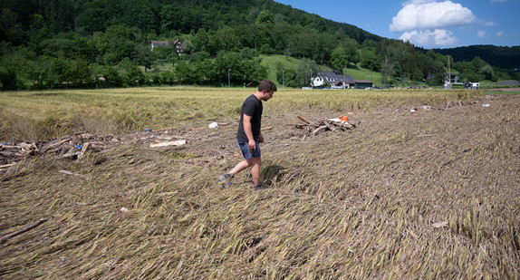 Ein Landwirt geht über ein überschwemmtes Wintergerstenfeld.