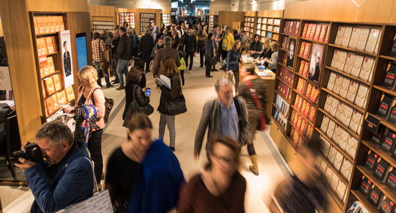 Besucher gehen zwischen Bücherregalen auf der Buchmesse in Frankfurt am Main (Hessen). (Bild: dpa).