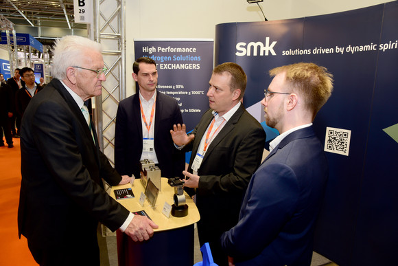 Ministerpräsident Winfried Kretschmann (l.) am Stand der smk systeme metall kunststoff gmbh & co. kg