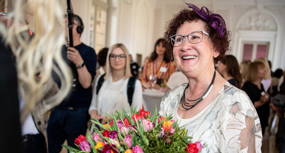 Gerlinde Kretschmann bekommt einen Blumenstrauß auf dem Frühlingsempfang im Neuen Schloss (Bild: © Fabian Sommer/dpa)