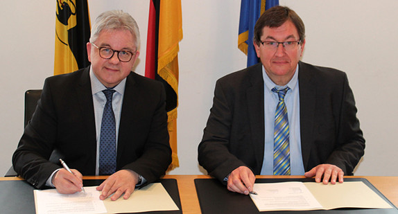 Der Minister der Justiz und für Europa, Guido Wolf (l.) und der Verbandsdirektor des Volkshochschulverbands Baden-Württemberg, Dr. Hermann Huba (r.) bei der Unterzeichnung einer Kooperationsvereinbarung über Rechtskundeseminare für Flüchtlinge und Asylbewerber (Foto: Justizministerium Baden-Württemberg)