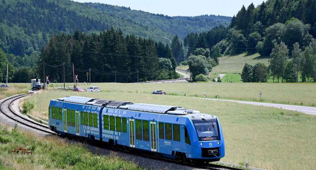 Ein Brennstoffzellenzug fährt durch eine Wiesenlandschaft im Netz der Zollernalbbahn bei Burladingen.