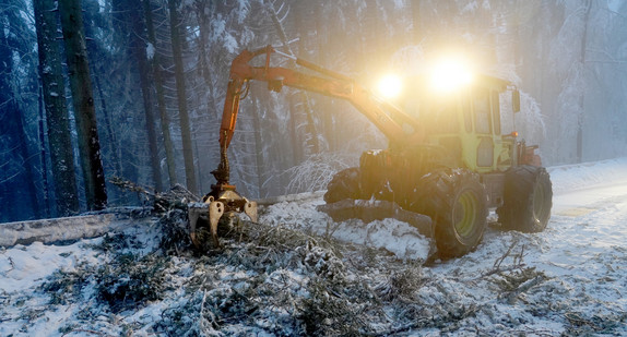 Ein Forstfahrzeug räumt nach einem Schneebruch eine Landstraße frei (Bild: © dpa)