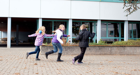 Schulkinder spielen Fangen