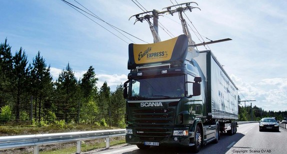 Ein Lkw mit Stromabnehmern fährt auf einer Straße entlang.