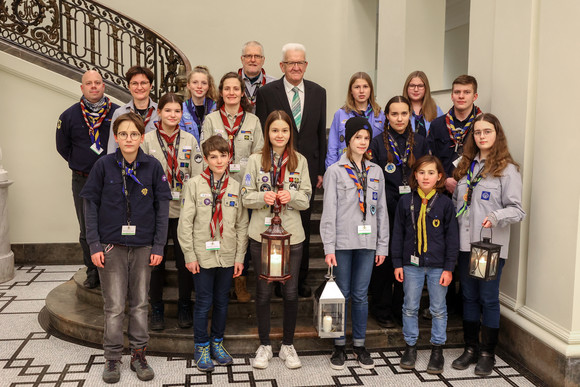 Ministerpräsident Winfried Kretschmann mit Pfadfinderinnen und Pfadfindern bei der Übergabe des „Friedenslichts“