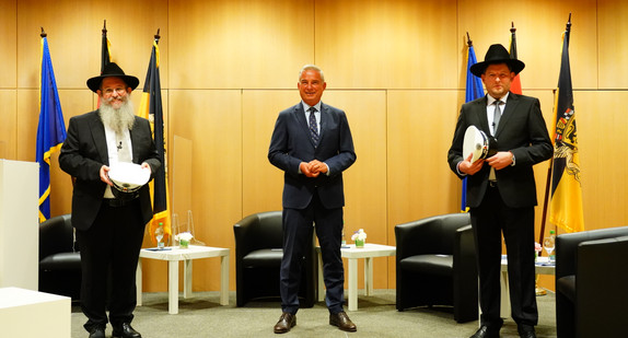 Minister Strobl und die beiden ersten Polizeirabbiner der Polizei Baden-Württemberg stehen für ein Foto zusammen.