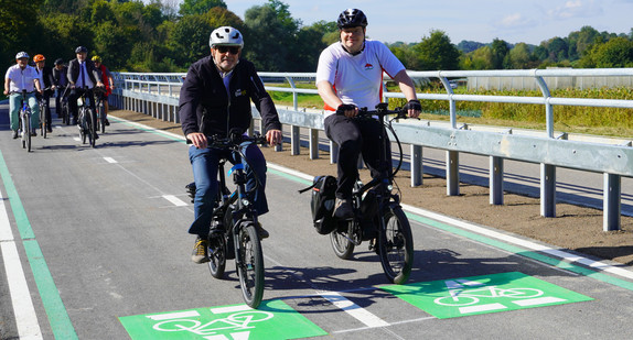 Verkehrsminister Winfried Hermann links und der Bürgermeister von Ebersbach, Eberhard Keller, fahren Fahrrad auf dem Radschnellweg im Filstal.