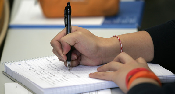 Eine Person schreibt mit einem Kugelschreiber Notizen in einen linierten Block. (Foto: © Wilhelm Mierendorf / Universität Mannheim)