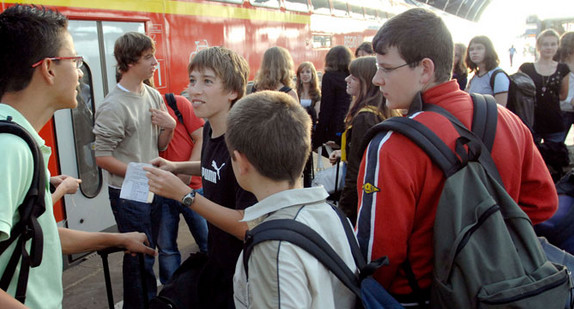 Eine Gruppe Schülerinnen und Schüler steht auf einem Bahnsteig vor einem Regionalexpress. (Bild: © Deutsche Bahn / Gustavo Alabiso)