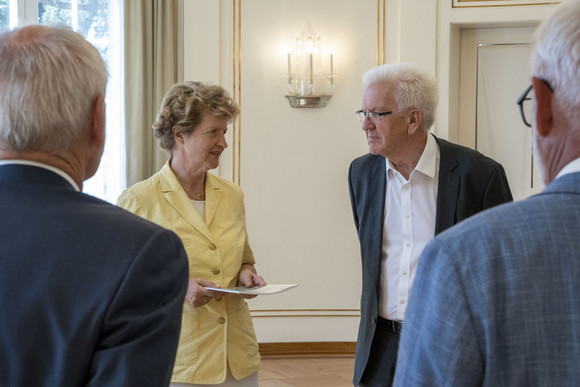 Dr. Gisela Meister-Scheufelen (zweite von links), Vorsitzende des Normenkontrollrats Baden-Württemberg, übergibt Ministerpräsident Winfried Kretschmann (zweiter von rechts) den Jahres- und Bilanzbericht 2021.