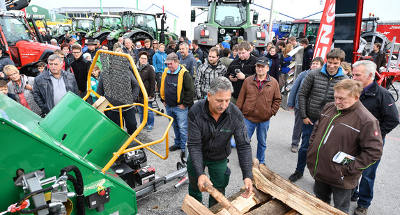 Besucher schauen sich bei der Oberschwabenschau in Ravensburg die Vorführung an einer Holzsägemaschine an. (Foto: © dpa)