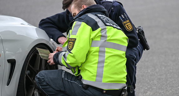 Polizisten kontrollieren ein Auto.