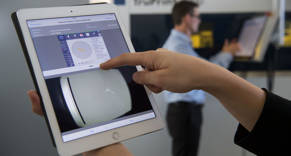 Eine Mitarbeiterin demonstriert die Bedienung einer 3D-Druck-Maschine per Tablet. (Foto: © dpa)