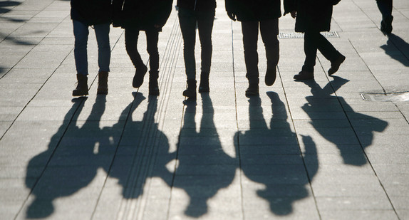 Fußgänger werfen ihre Schatten auf die Straße. (Foto: dpa)