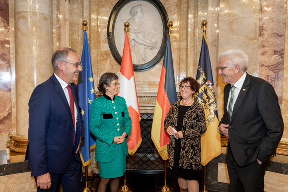 (von links nach rechts:) Guy Parmelin, Caroline Parmelin, Gerlinde Kretschmann und Winfried Kretschmann unterhalten sich heiter.