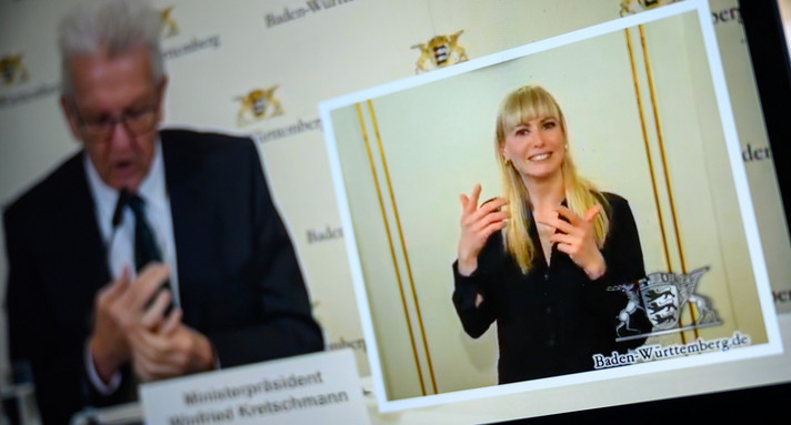 Bei einer Pressekonferenz von Ministerpräsident Winfried Kretschmann übersetzt eine Gebärdendolmetscherin.