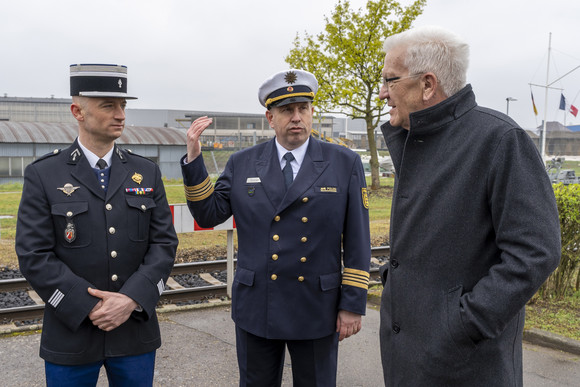 Ministerpräsident Winfried Kretschmann (rechts) im Gespräch mit zwei Polizisten der Wasserschutzpolizeistation in Kehl.