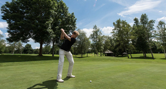 Ein Golfer spielt den Ball. (Bild: © picture alliance/Patrick Seeger/dpa)