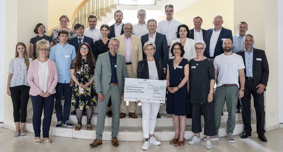 Gruppenbild mit Ministerin Dr. Hoffmeister-Kraut: Bescheidübergabe im Neuen Schloss an sechs Projektträger für Weiterbildungsprojekte im Bereich nachaltiges Bauen.