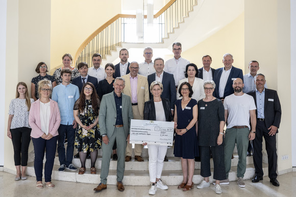 Gruppenbild mit Ministerin Dr. Hoffmeister-Kraut: Bescheidübergabe im Neuen Schloss an sechs Projektträger für Weiterbildungsprojekte im Bereich nachaltiges Bauen.