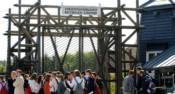 Eine Deutsche Schülergruppe steht vor dem Eingang zum Konzentrationslager Natzweiler – Struthof in den elsässischen Vogesen (Bild: © dpa).