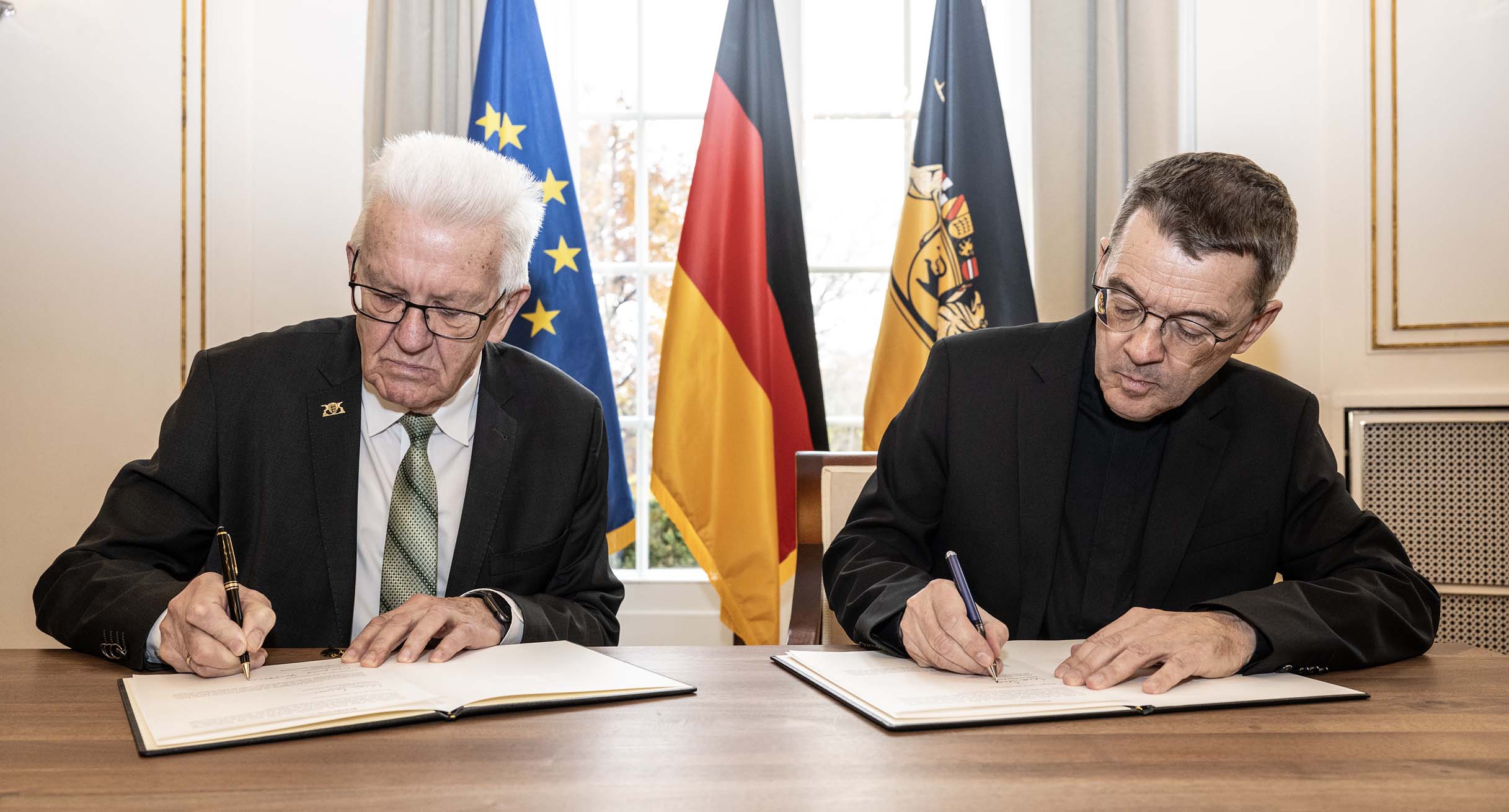 Ministerpräsident Winfried Kretschmann (links) und der designierte Bischof von Rottenburg-Stuttgart, Prälat Dr. Klaus Krämer (rechts), bei der Unterzeichnung der Erklärung.