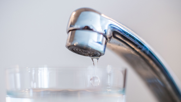 Wasser läuft aus einem Wasserhahn in ein Glas. (Foto: © dpa)