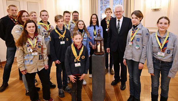 Jugendliche Pfadfinderinnen und Pfadfinder übergeben Ministerpräsident Winfried Kretschmann (dritter von rechts) das Friedenslicht aus Bethlehem.