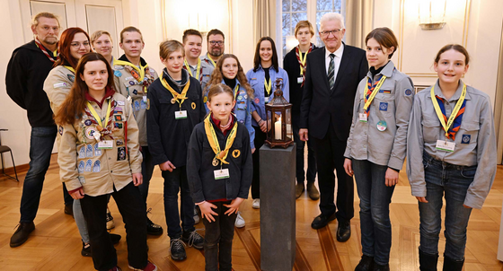 Jugendliche Pfadfinderinnen und Pfadfinder übergeben Ministerpräsident Winfried Kretschmann (dritter von rechts) das Friedenslicht aus Bethlehem.