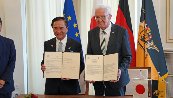 Ministerpräsident Winfried Kretschmann und Gouverneur Yuji Kuroiwa zeigen die unterzeichnete Gemeinsame Absichtserklärung zwischen Baden-Württemberg und Kanagawa.